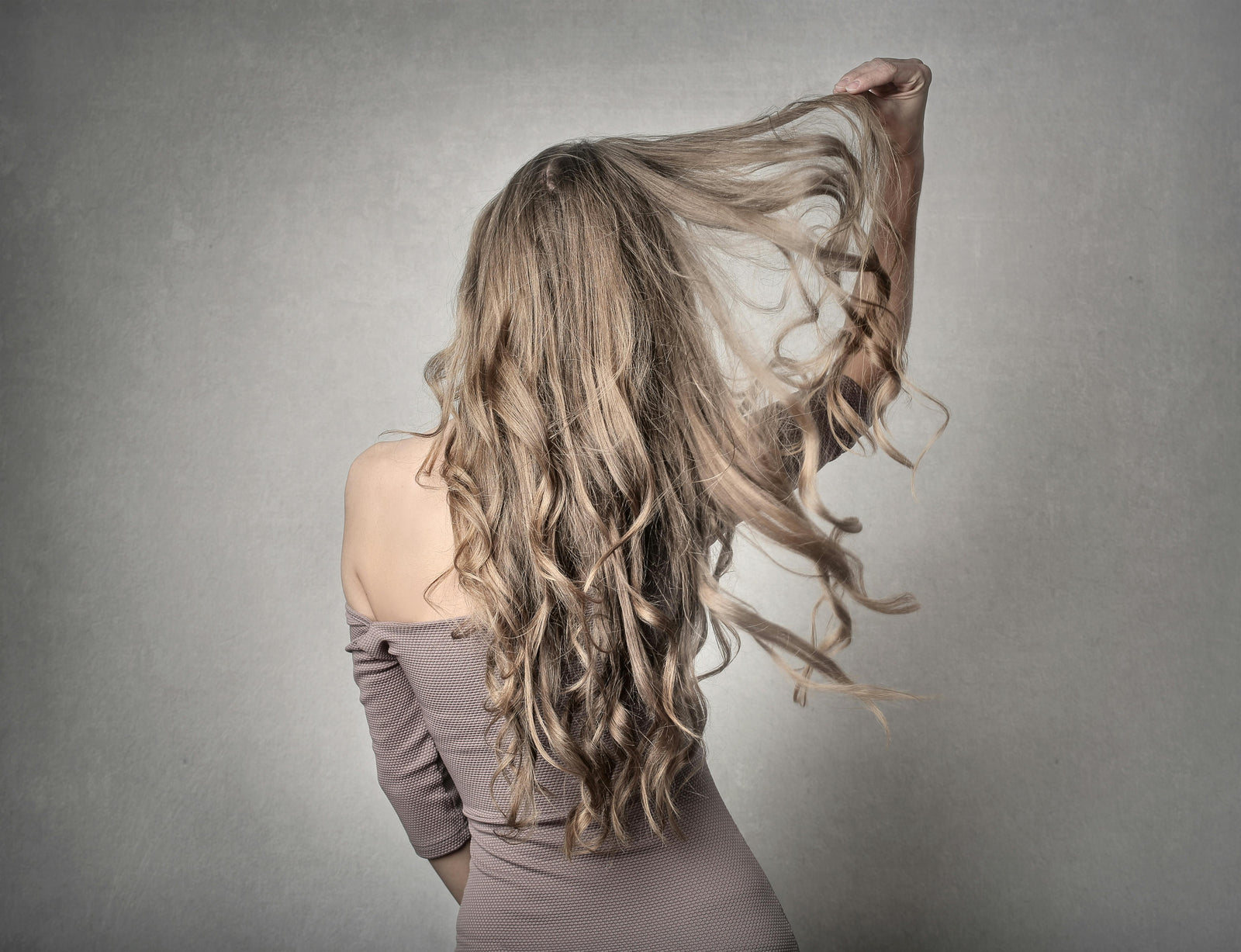 Donna che osserva capelli caduti sulla spazzola, simbolo del problema della caduta dei capelli
