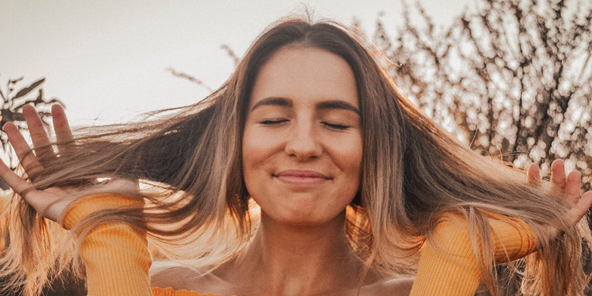 Donna con capelli lunghi sani e lucenti, esempio di chioma curata e luminosa